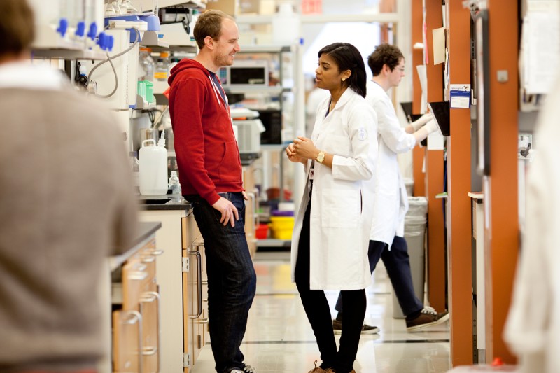 GSK student talking to a researcher in a laboratory.