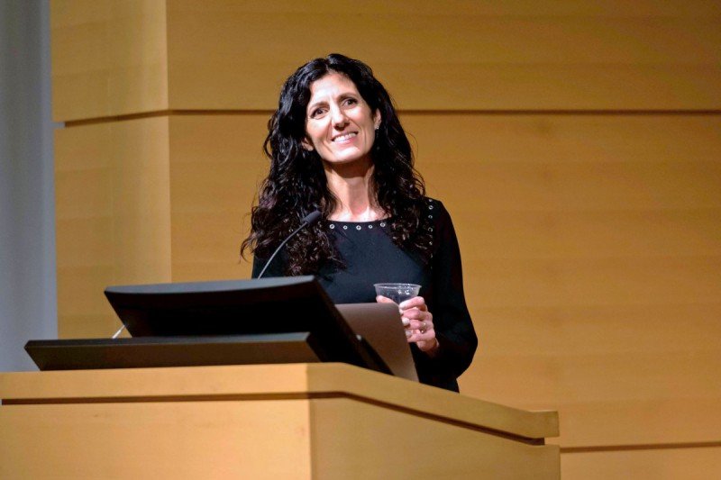 A female scientist speaking at a podium