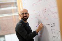 Bioinformatician Ahmet Zehir stands at a whiteboard