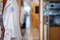 A lab coat with an MSK logo hangs on a hook