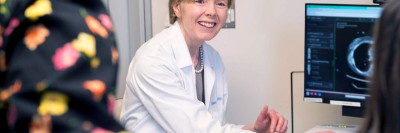 Dr. O'Reilly is showing her patient an image on a monitor in an MSK exam room.