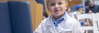A smiling young boy participates in the 2026 MSK Kids Talent show with other patients and MSK staff.  